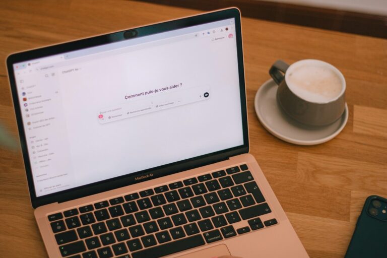 Laptop and coffee on a wooden table.
